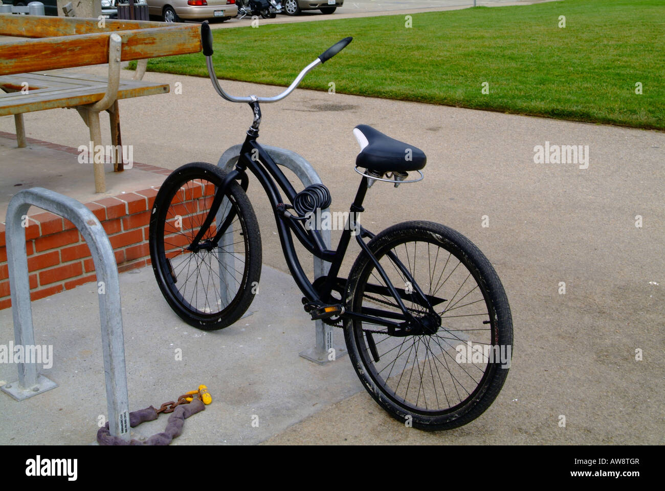 Un surfeur croisière vélo verrouillé jusqu'au garde-corps. Banque D'Images