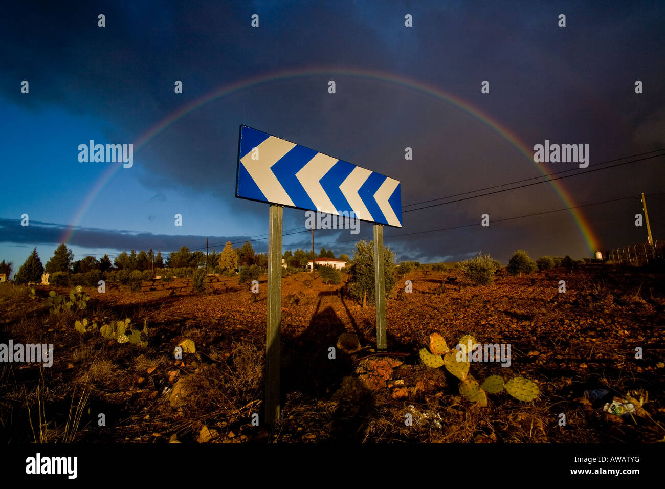 Un arc-en-ciel complet entoure un signe de la circulation près de Ronda, Espagne Banque D'Images