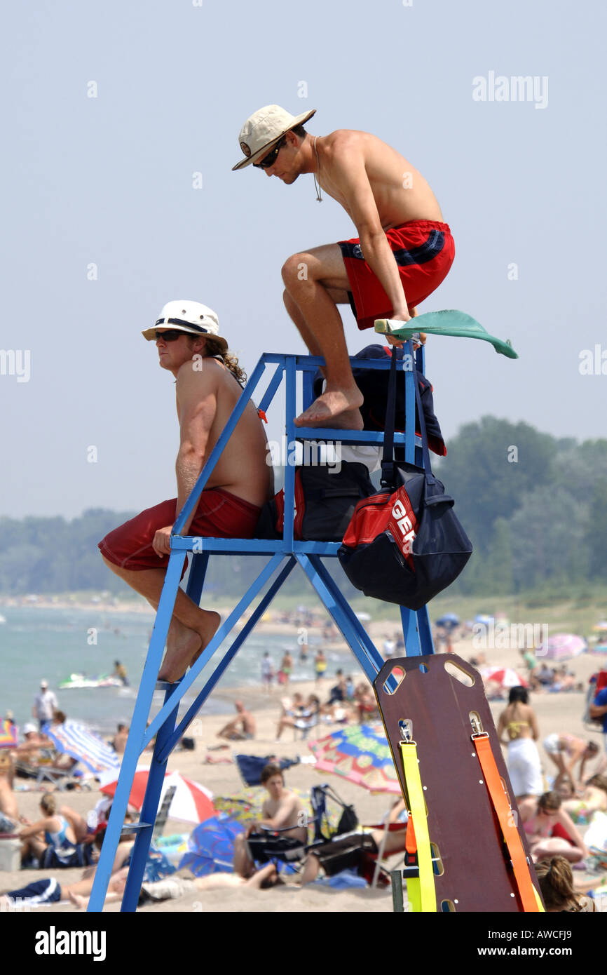 Une plage surveillée assis dans une tour en gardant un œil sur les baigneurs Banque D'Images