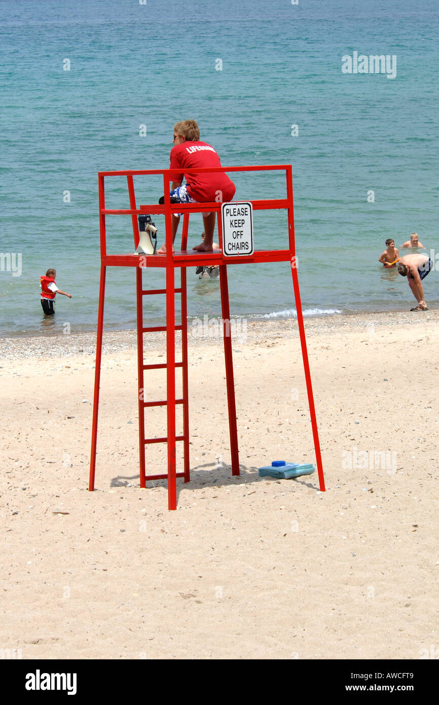 Plage surveillée vêtu de rouge s'asseoir à son tour Banque D'Images