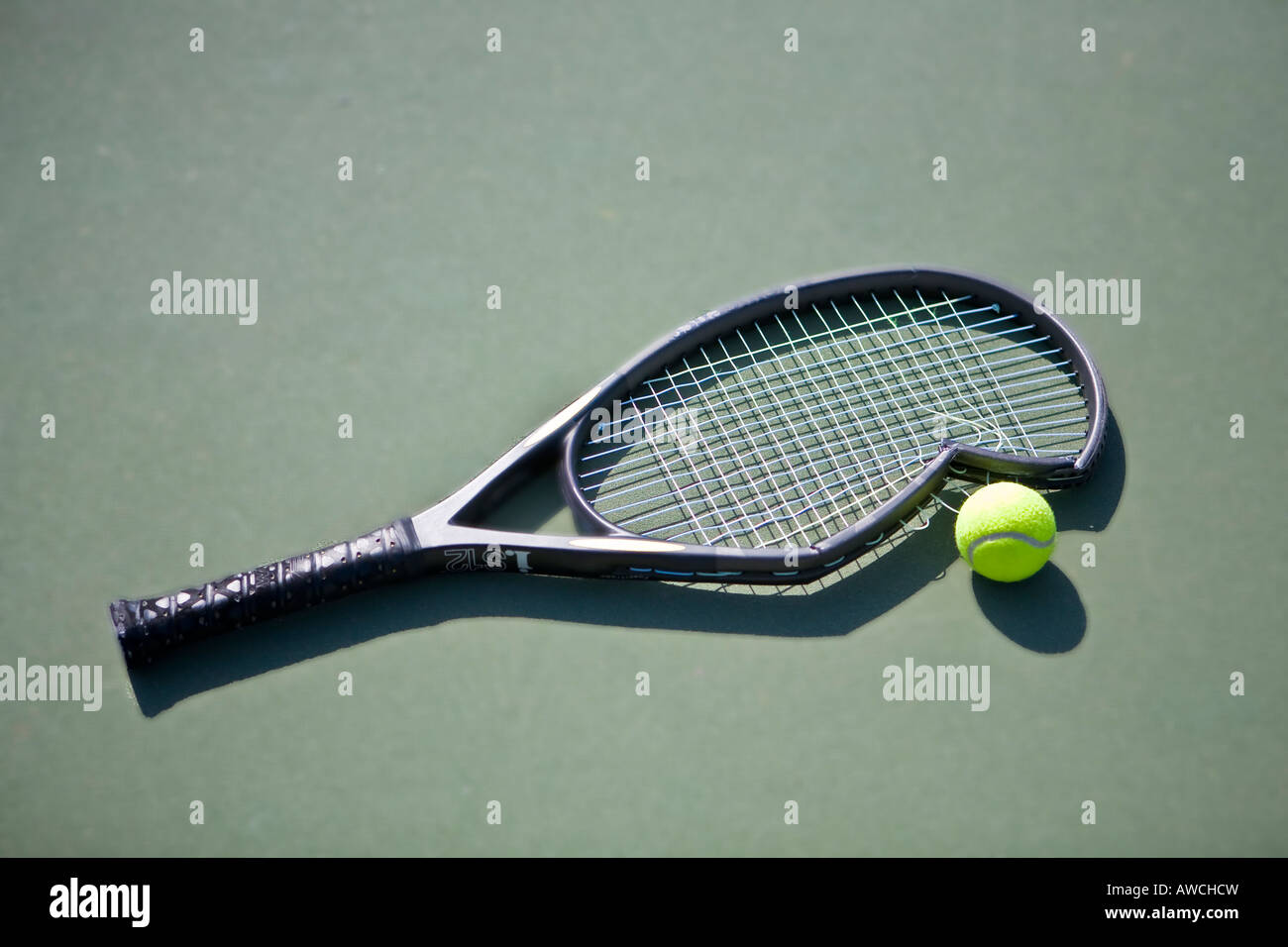 Raquette de tennis cassée sur le green court avec balle de tennis Photo  Stock - Alamy