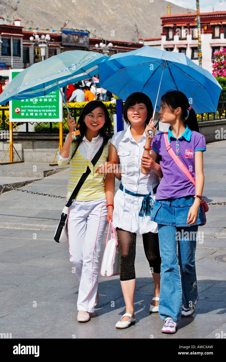 Trois jeunes dames chinoises avec parasols, Barkor, Lhassa, Tibet Banque D'Images