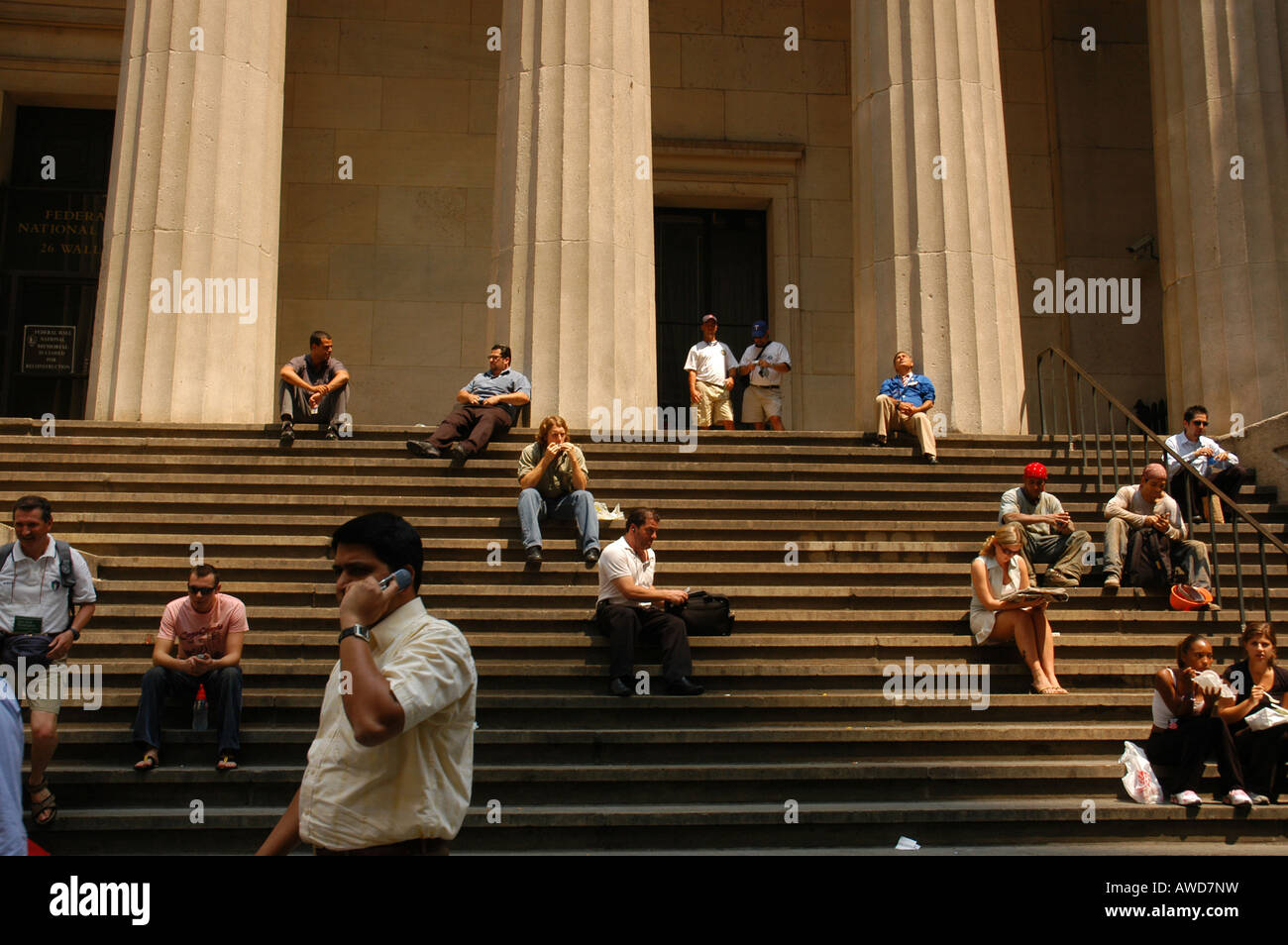 Les gens assis devant la Federal Hall, New York USA Banque D'Images