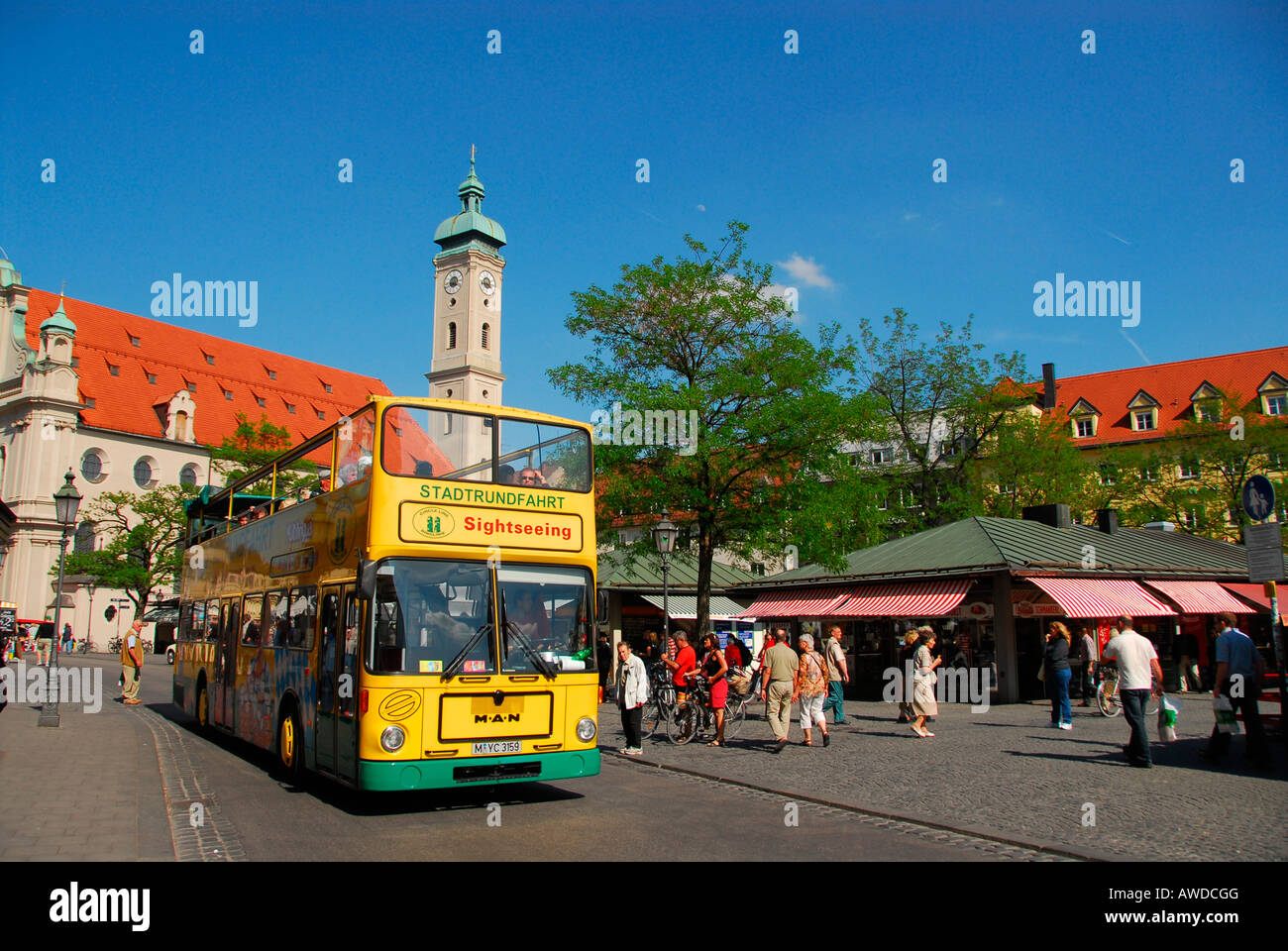 Bus touristique en face de l'Église Saint-esprit (Heilig-Geist-Kirche) au Viktualienmarkt, Munich, Bavière, Allemagne Banque D'Images