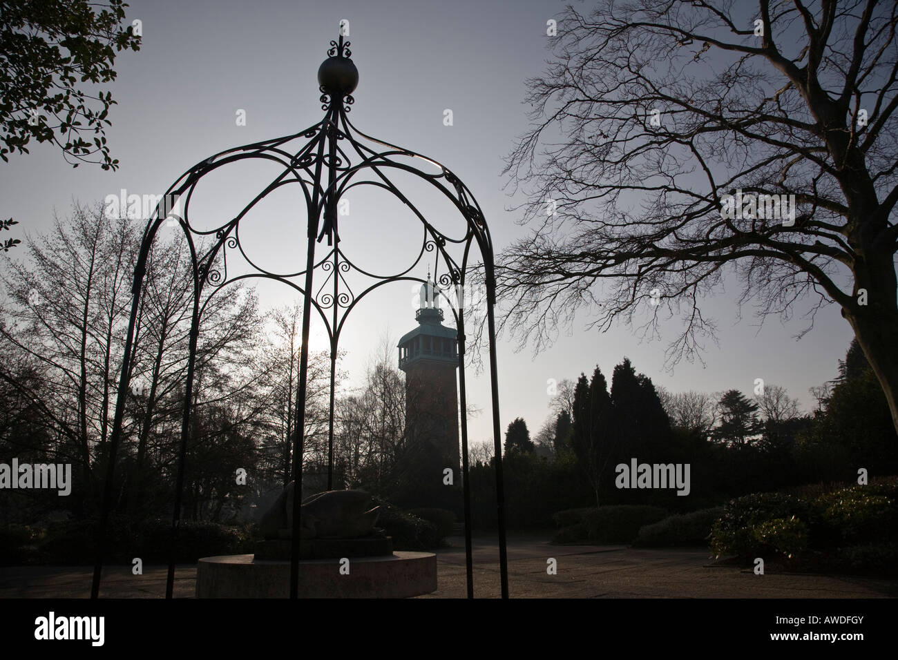 Une pergola en fer forgé couvre une statue avec le Carillon de clocher dans silohuetted l'arrière-plan. Loughborough, Angleterre. Banque D'Images