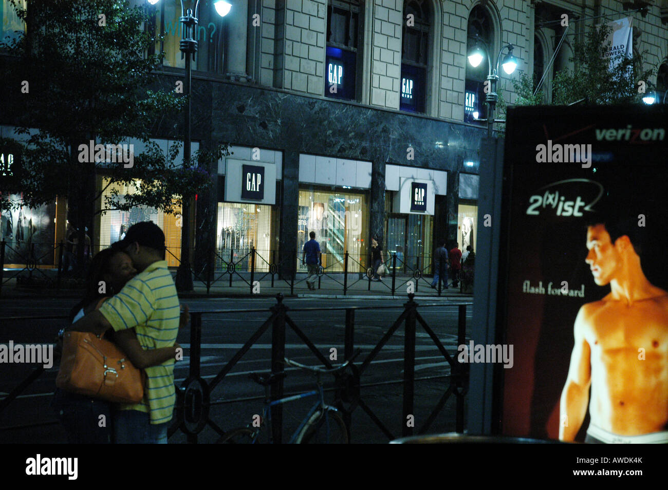 Couple embrasser l'homme dans une publicité regarder New York USA Banque D'Images