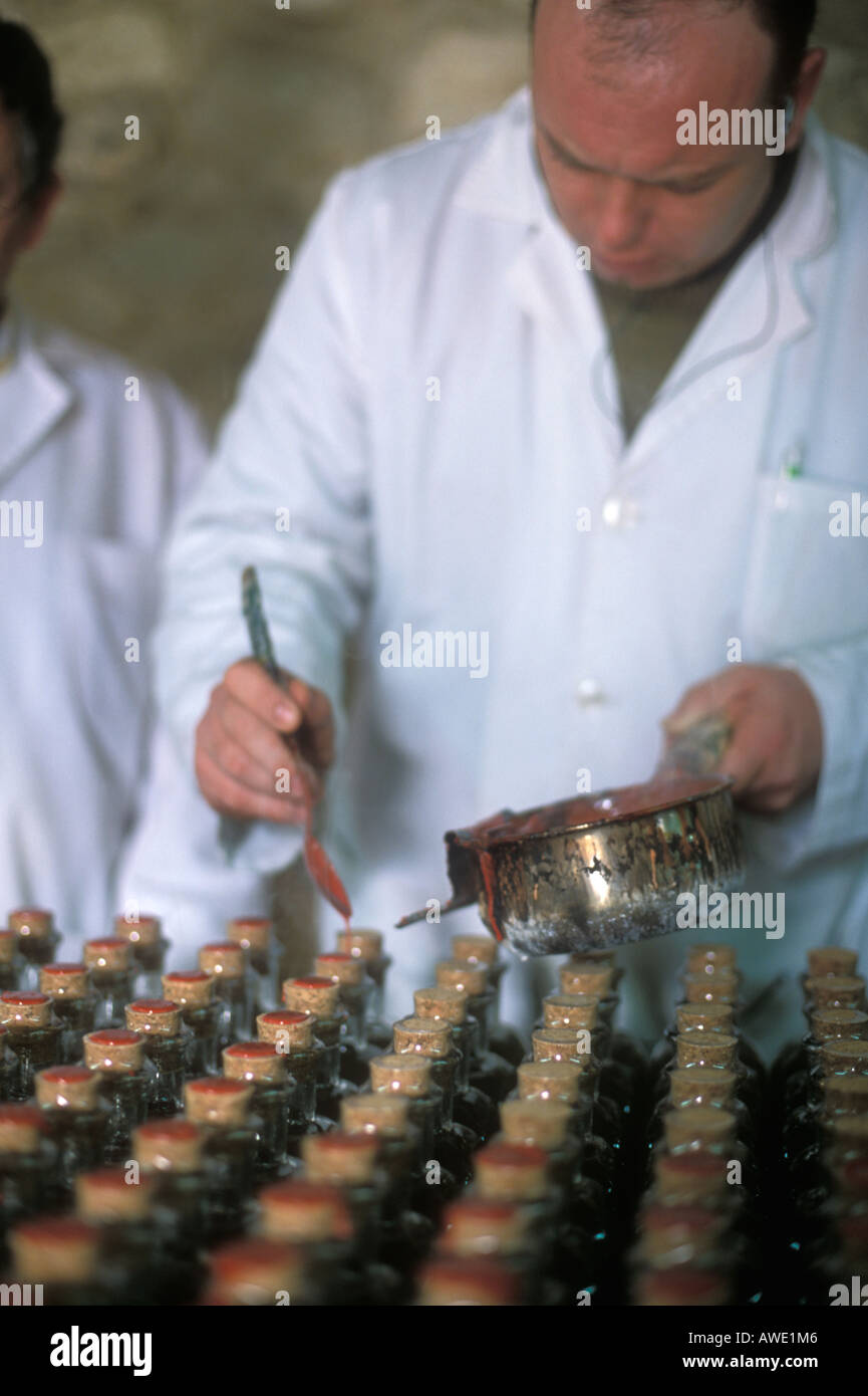 L'huile d'olive d'étanchéité en cire des bouteilles sur la Nunez de Prado, l'usine d'huile d'olive BAENA, Espagne Banque D'Images