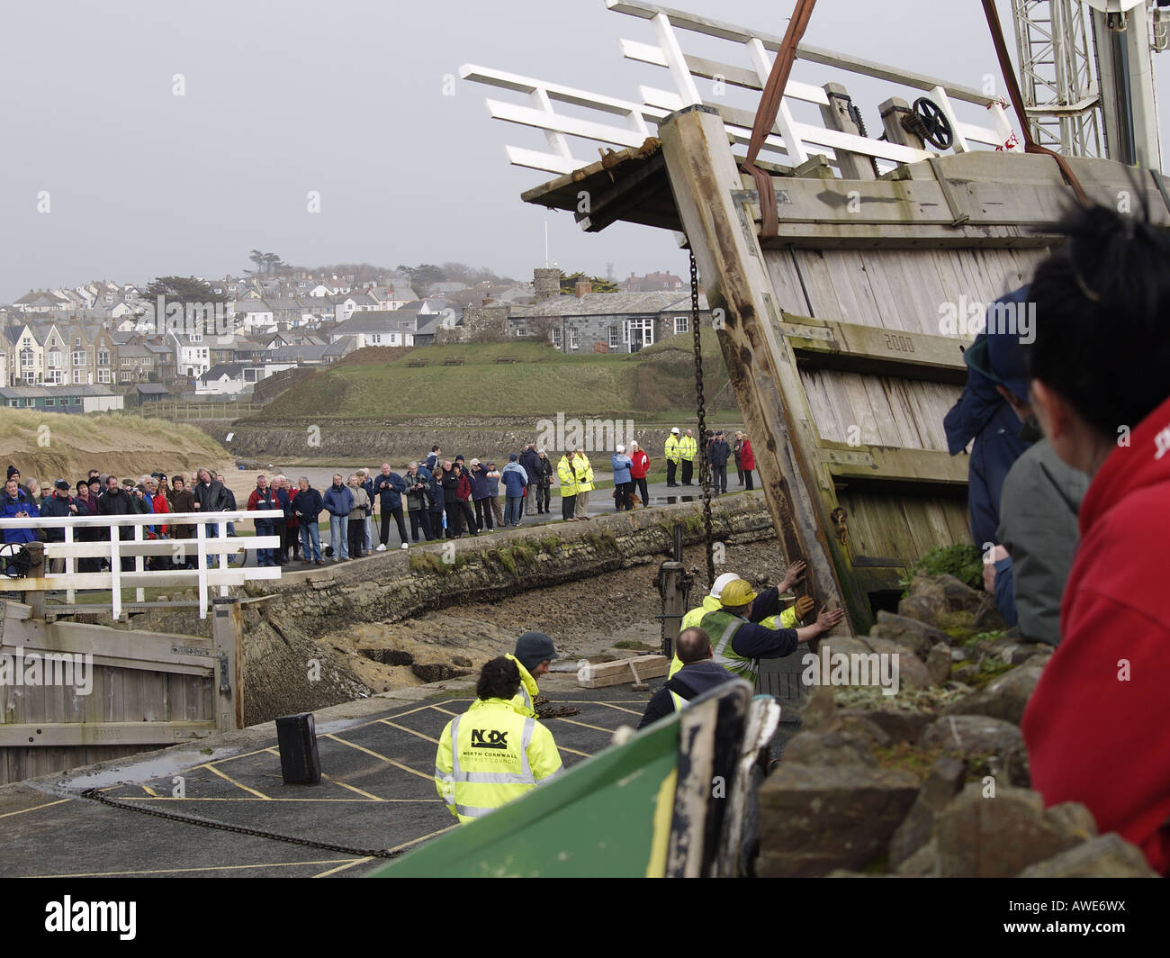 Grande foule de personnes regardant la mer du canal de Bude verrouiller la porte d'être supprimé par crane après avoir été endommagé dans le 10 mars 2008 tempête. Banque D'Images