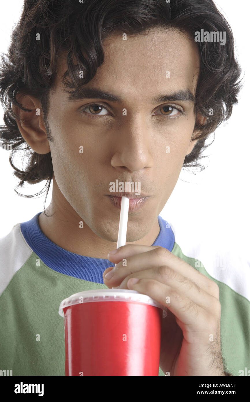ANG200451 Teenage boy holding verre de boire des boissons gazeuses avec paille smiling MR 687T Banque D'Images