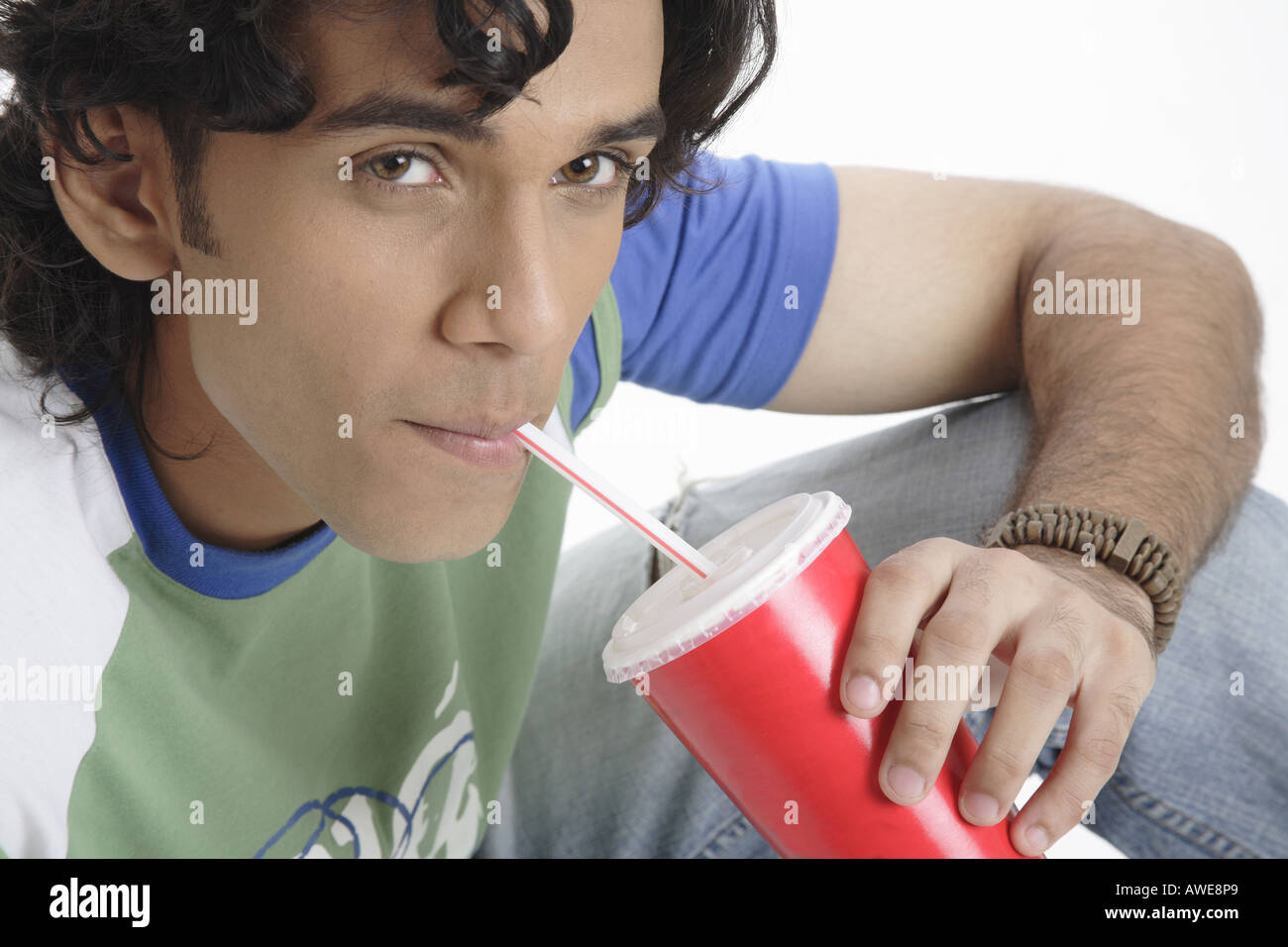 ANG200457 Teenage boy holding verre de boire des boissons gazeuses avec paille smiling MR 687T Banque D'Images