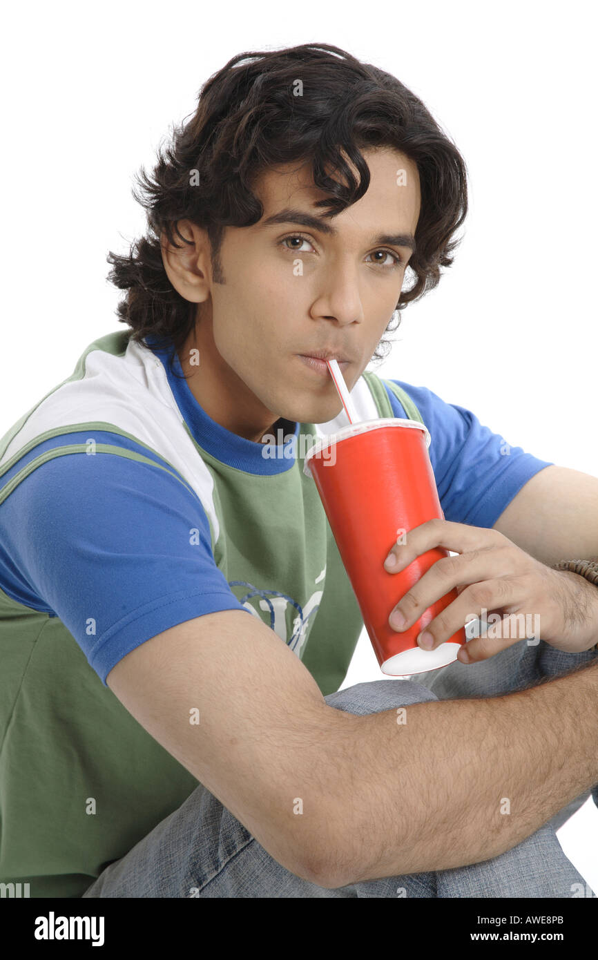 Teenage boy holding verre de boire des boissons gazeuses avec paille smiling MR 687T Banque D'Images