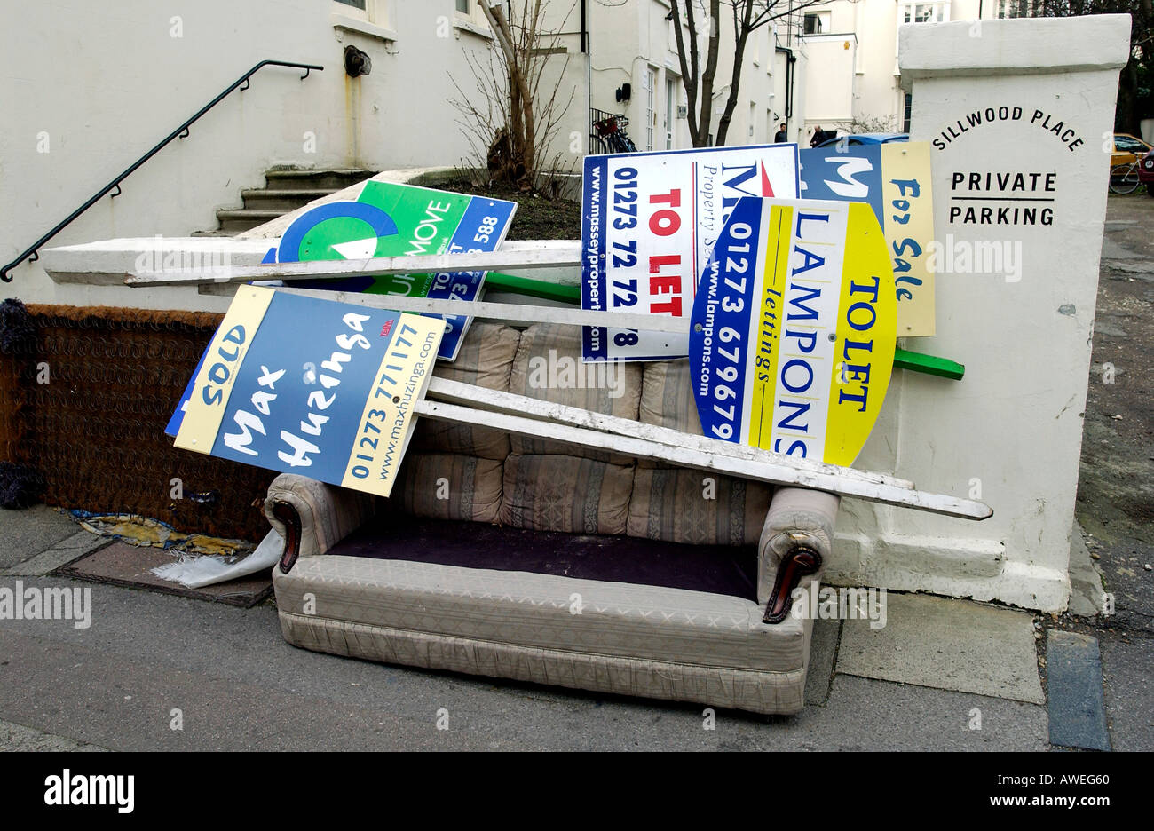 Maison à vendre ou à laisser les signes sont déchirées et déposé sur un canapé abandonné dans une rue de Brighton East Sussex Banque D'Images