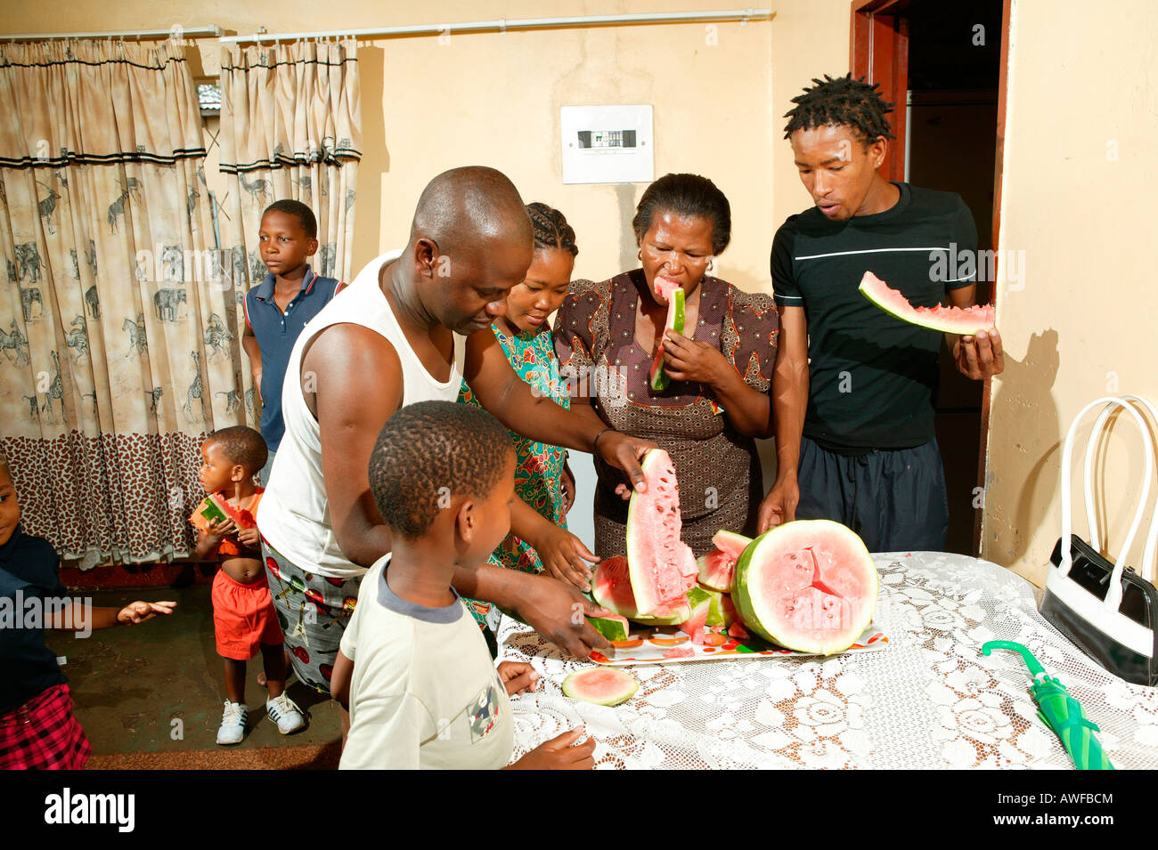 Famille élargie de manger le melon, Gaborone, Botswana, Africa Banque D'Images
