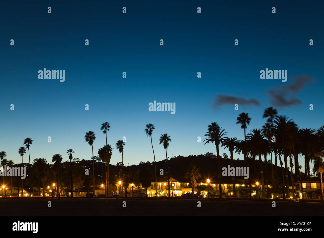 CALIFORNIA Santa Barbara lumières dans les bâtiments de l'hôtel Cabrillo Boulevard au crépuscule sur les palmiers et la montagne Banque D'Images