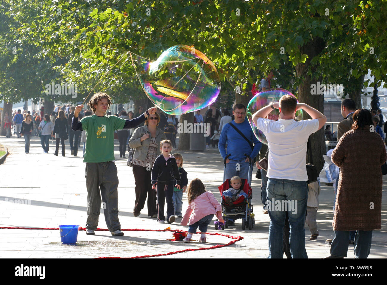 Un artiste de rue bulles géantes coups pour divertir les touristes et les enfants près du London Eye sur la Thames London England UK UE Banque D'Images