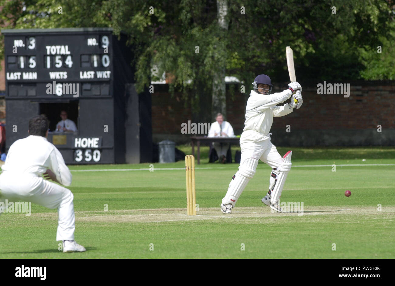 Un batteur sculpte le ballon dans un match de cricket UK Banque D'Images