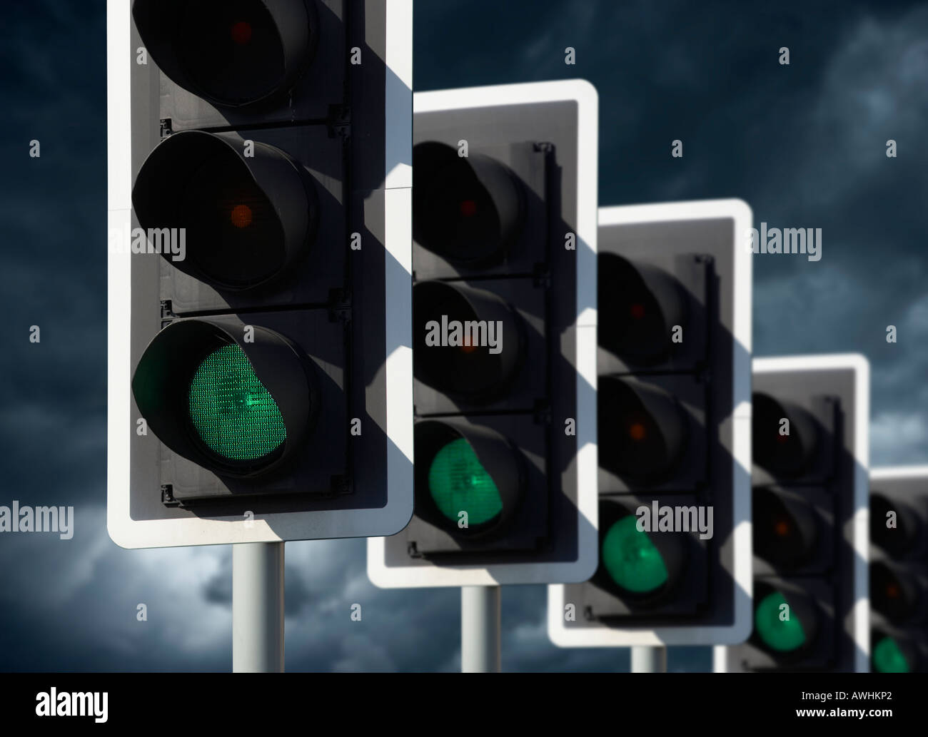 Rangée de cinq feux de circulation routière montrant VERT AVEC CIEL D'ORAGE Banque D'Images
