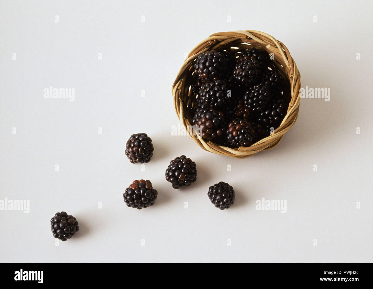 Les mûres s'échappant du panier Banque D'Images