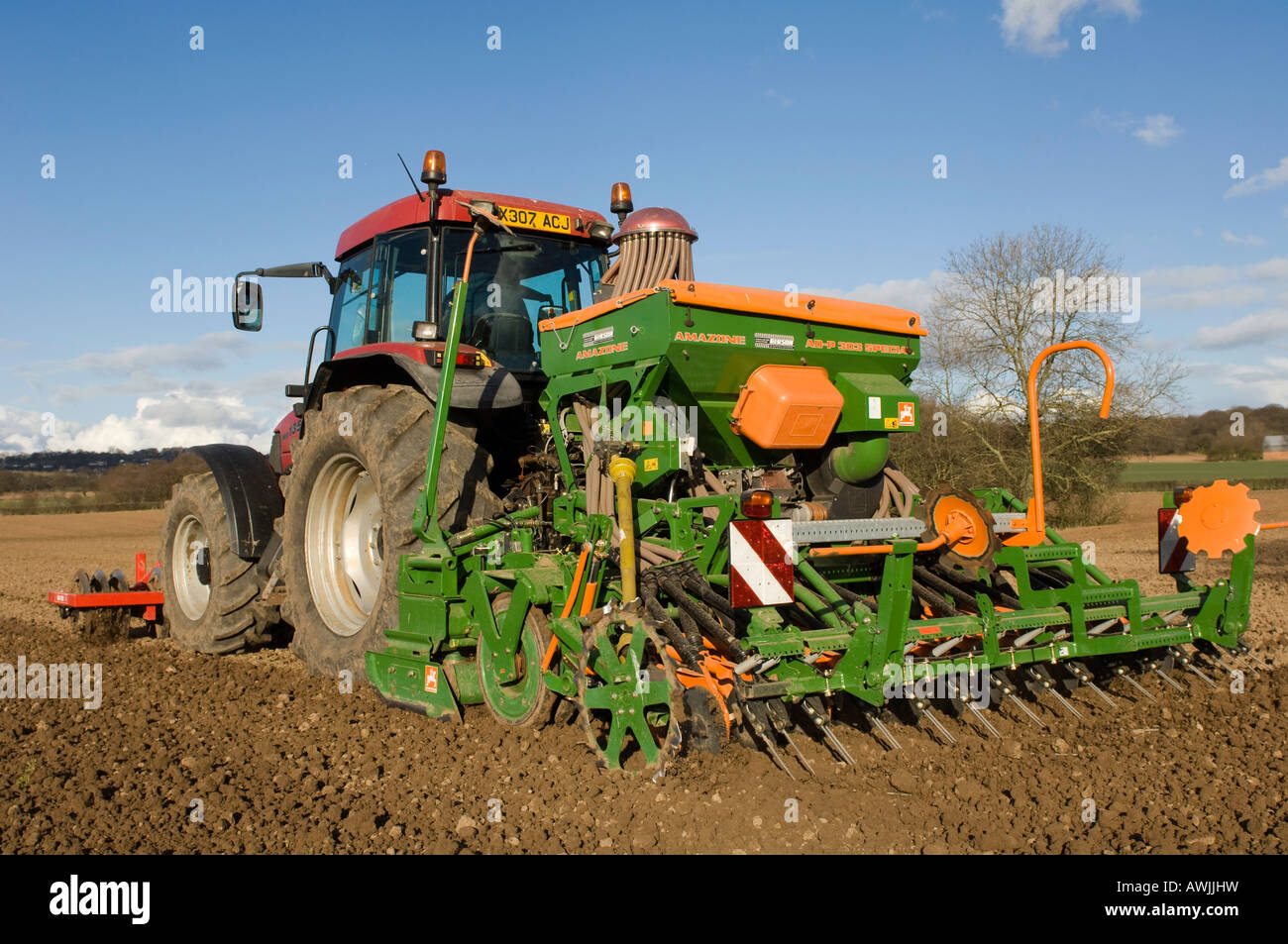 La plantation d'agriculteur haricots avec un semoir pneumatique monté sur un tracteur Maxxum Case équipé de disques montés à l'avant Banque D'Images