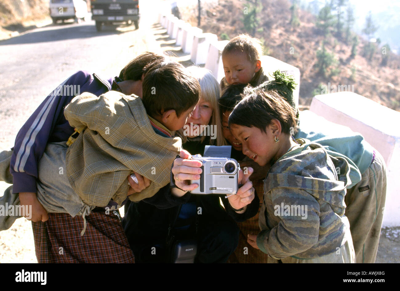 Bhoutan enfants bhoutanais réunis autour d'une caméra vidéo Banque D'Images