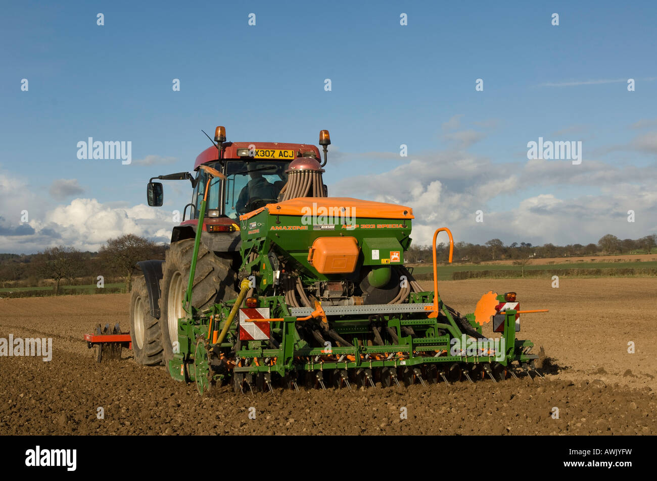 La plantation d'agriculteur haricots avec un semoir pneumatique monté sur un tracteur Maxxum Case équipé de disques montés à l'avant Banque D'Images
