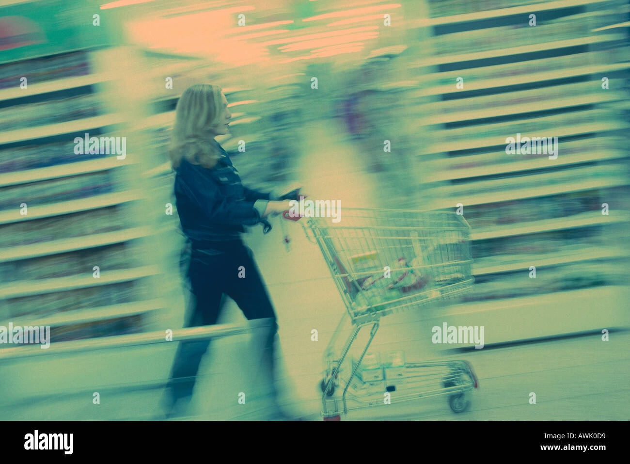 Vue latérale d'une femme poussant un chariot dans un supermarché Allemagne Europe Banque D'Images
