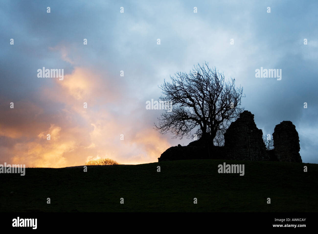 Château de Pendragon, Mallerstang dale, silhouette contre le ciel de lever de soleil orageux. Cumbria. ROYAUME-UNI Banque D'Images
