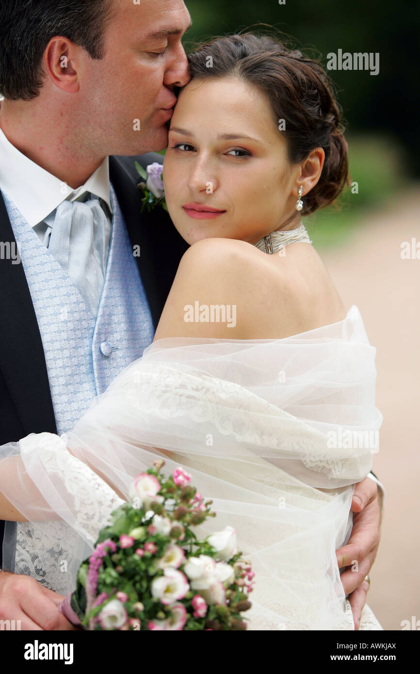Beautiful smiling mariée en robe blanche avec voile sur Faire place au jour de mariage son nouveau mari Banque D'Images