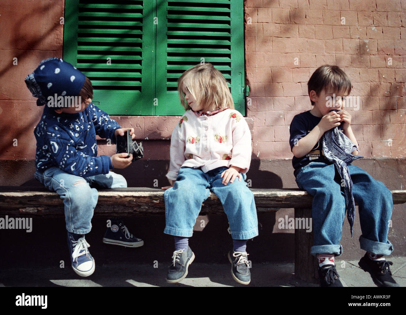 Les enfants assis sur un banc Banque D'Images