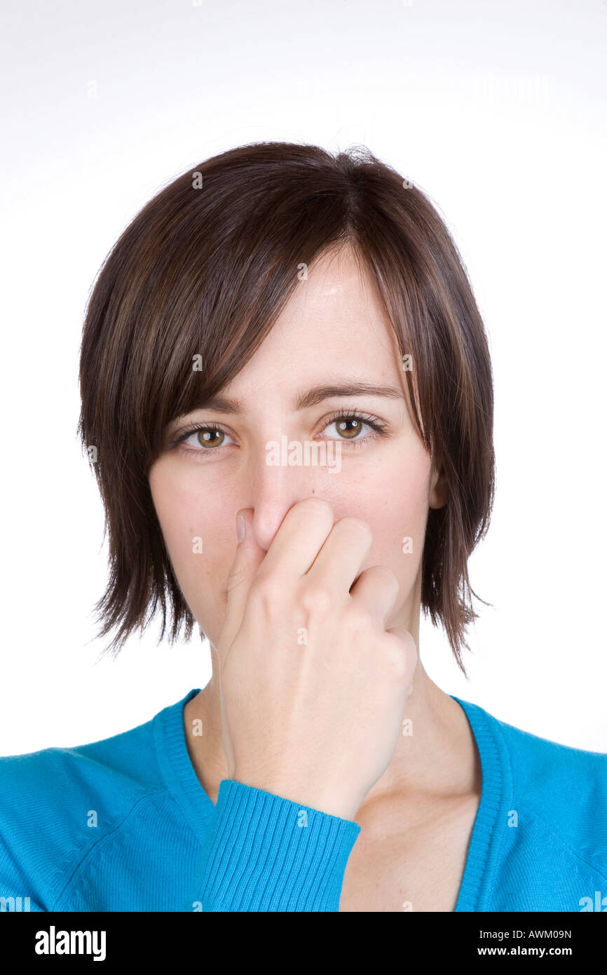 Jeune femme tenant son nez Banque D'Images