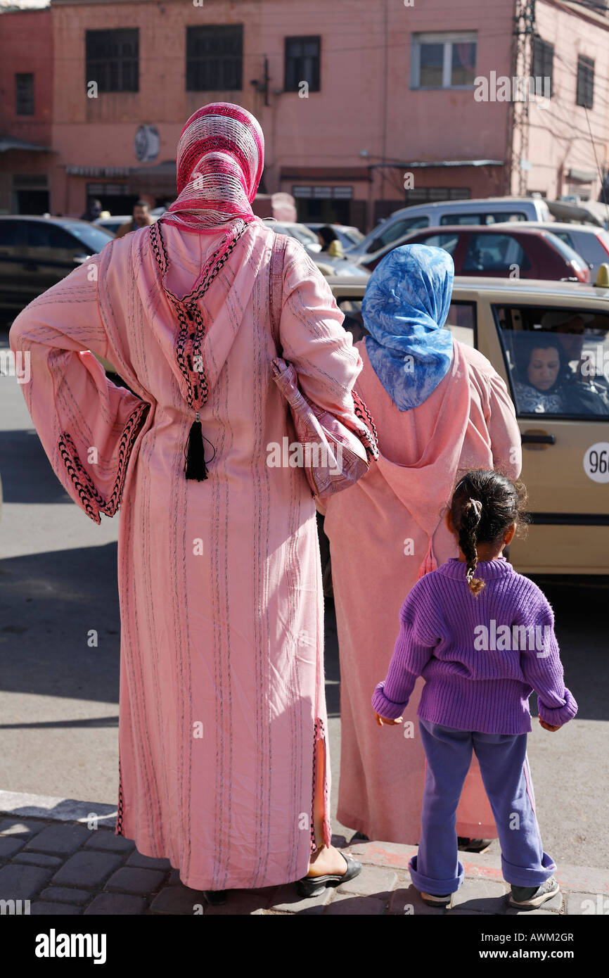 Deux femmes portant des djellabas roses et une petite fille attendant au bord de la route dans le quartier historique de la Medina de Marrakech au Maroc Photo Stock Alamy