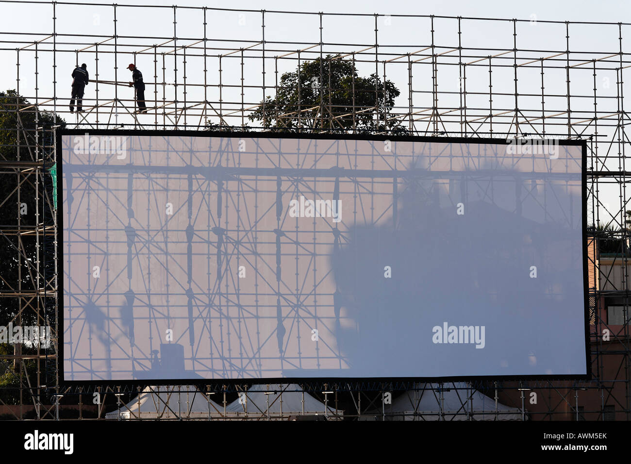 Deux hommes installant un énorme écran en plein air, Djemaa el-Fna, Marrakech, Maroc, Afrique Banque D'Images