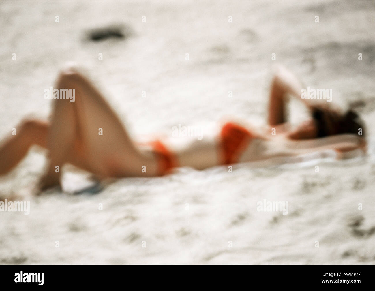 Femme en costume de bain, allongé sur le sable, blurred Banque D'Images