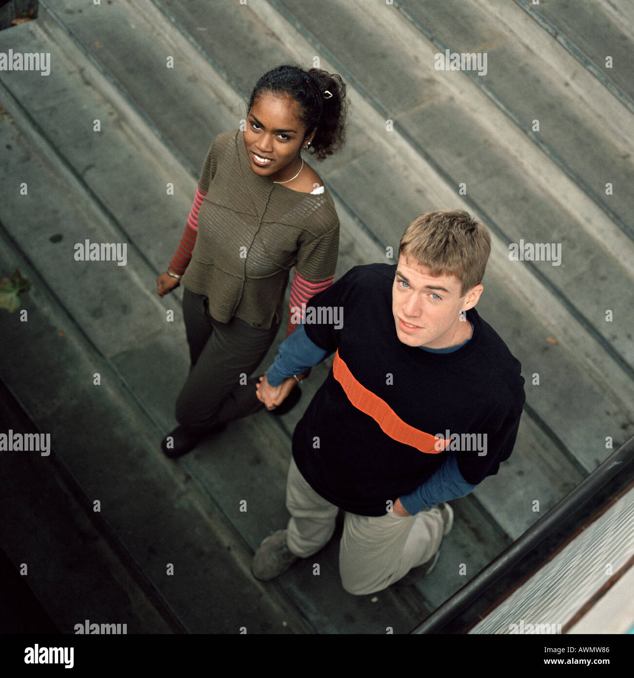 Jeune couple en bas de marche, à la recherche jusqu'à l'appareil photo, high angle view Banque D'Images