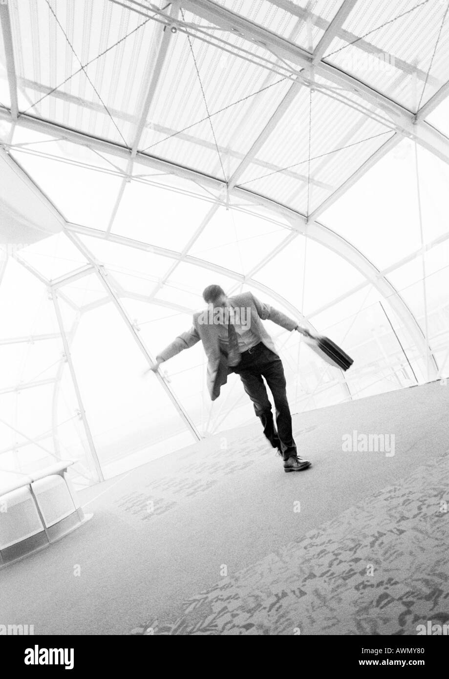 Businessman danse avec porte-documents en main, b&w. Banque D'Images