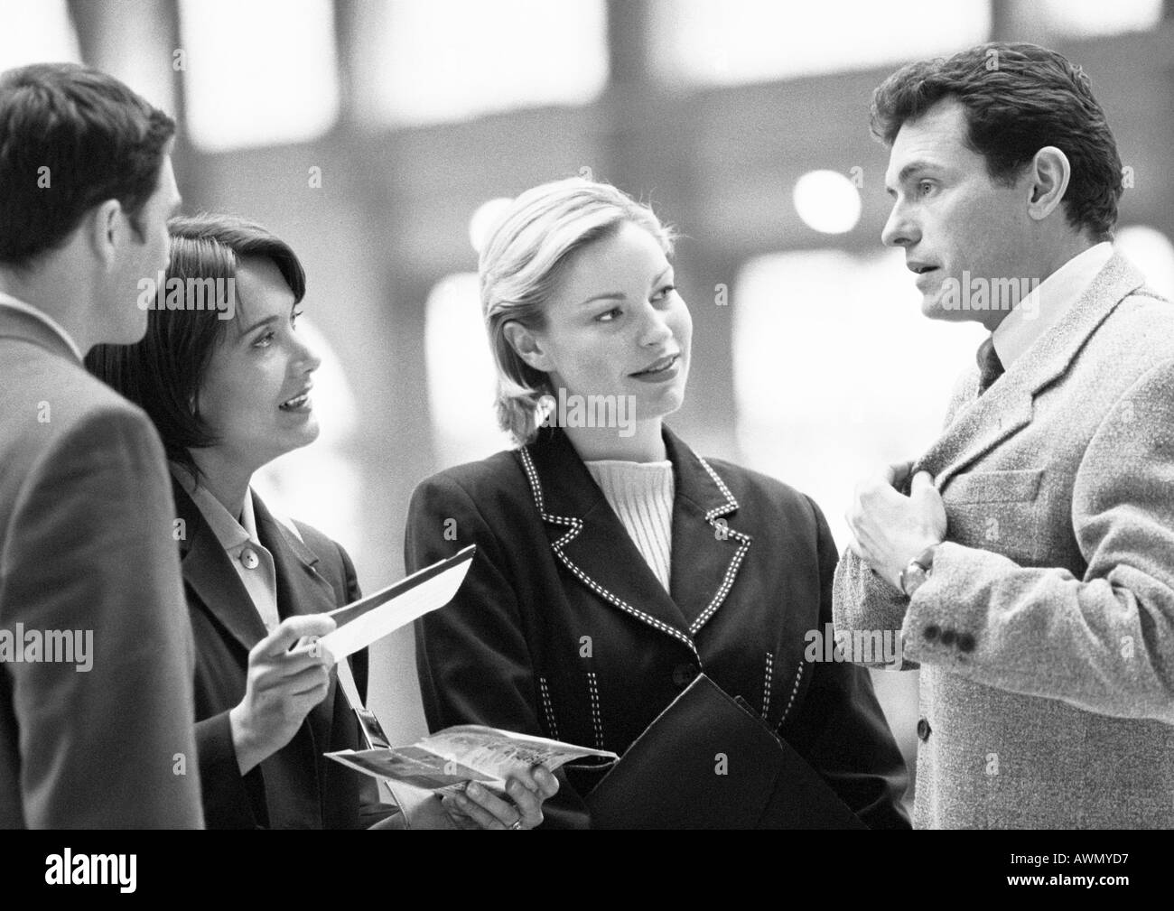 Business people talking, un holding ticket, b&w. Banque D'Images