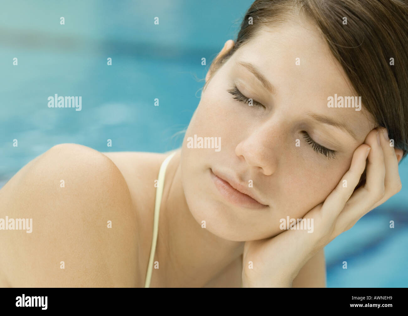 Femme se prélasser à la piscine, les yeux fermés Banque D'Images