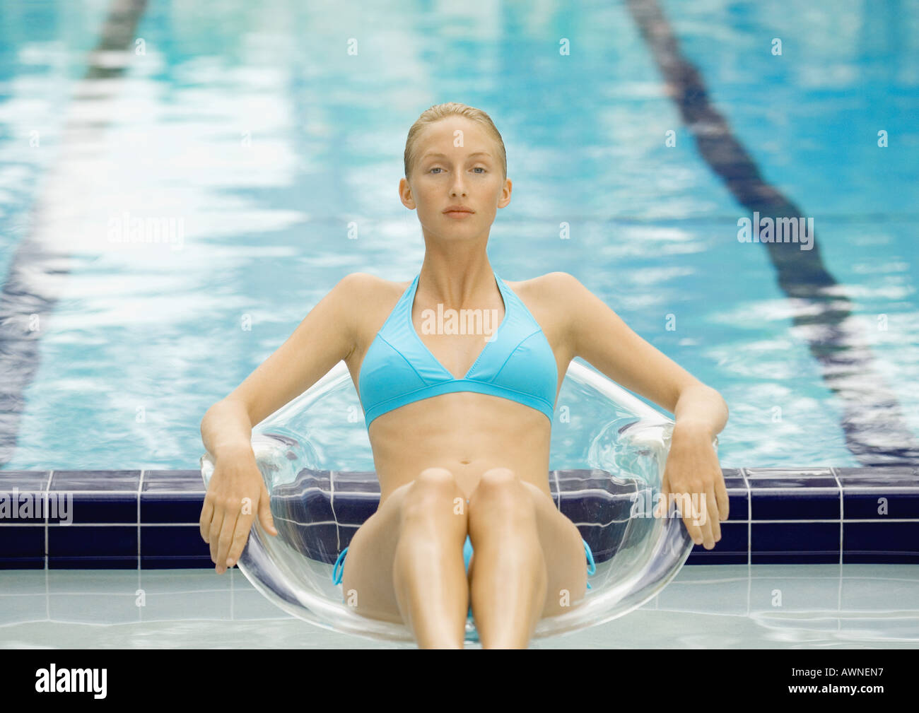 Woman in bikini assis en chaire par extérieure transparente Banque D'Images