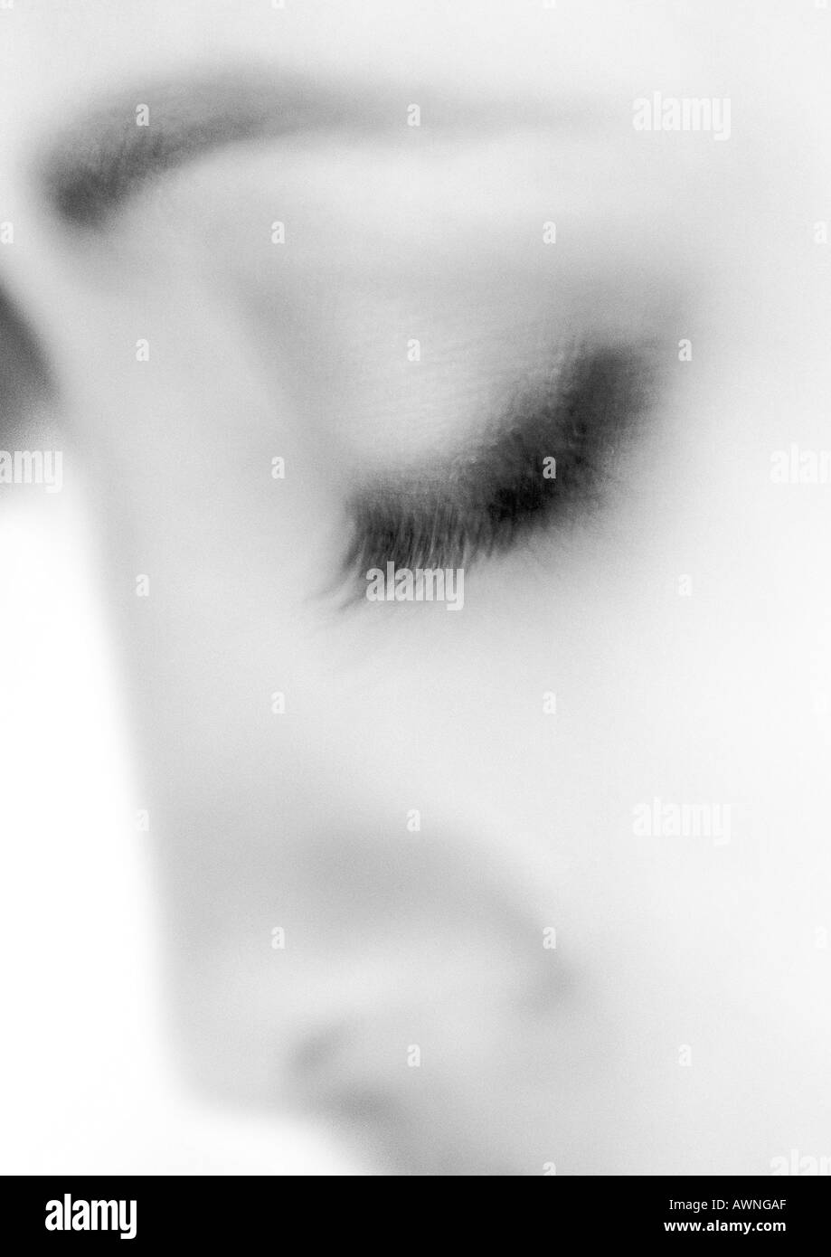La femme, l'oeil fermé floues, close-up, noir et blanc. Banque D'Images