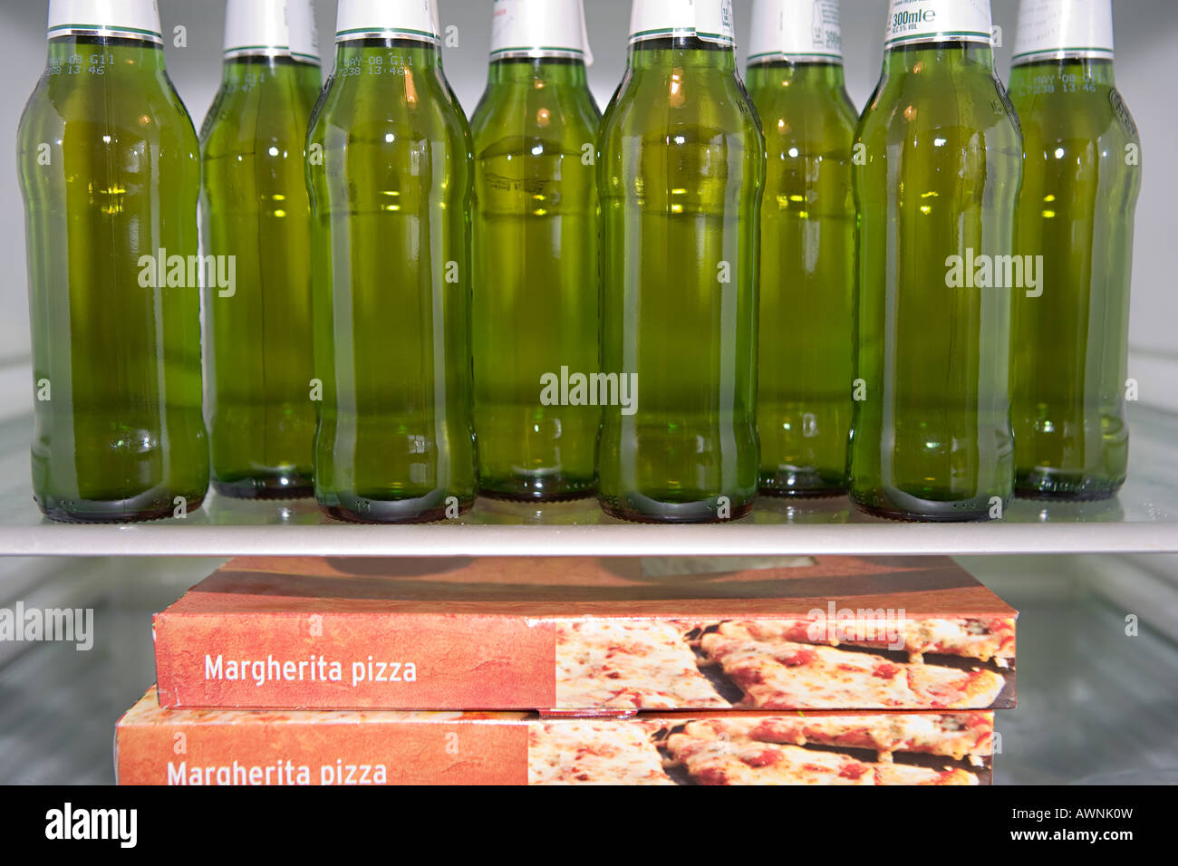 Bouteilles de bière et de pizza dans un réfrigérateur Banque D'Images