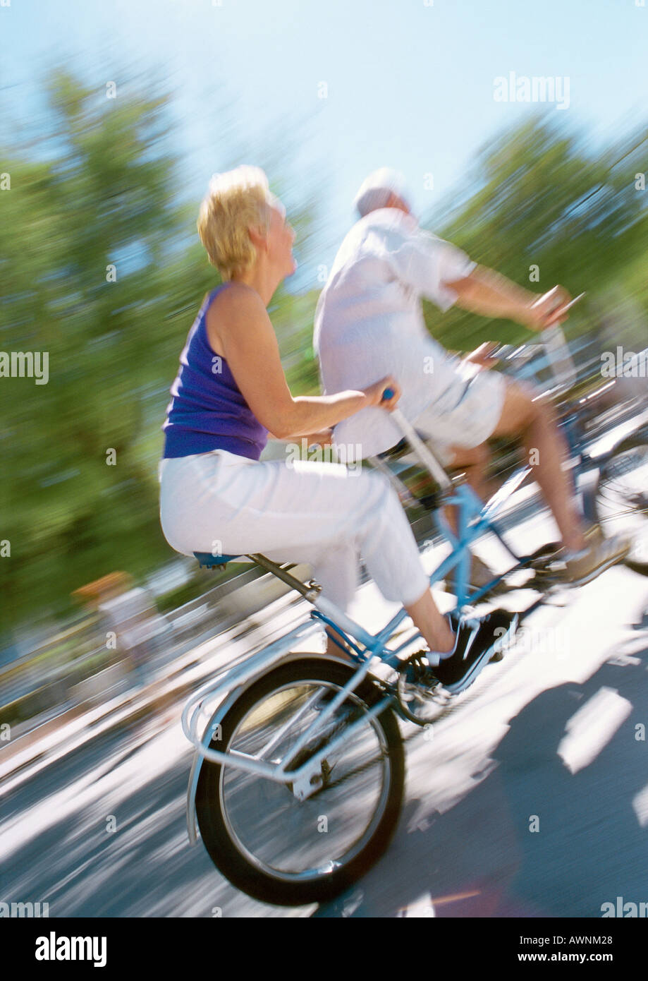 Man and Woman riding ensemble sur tandem, blurred Banque D'Images