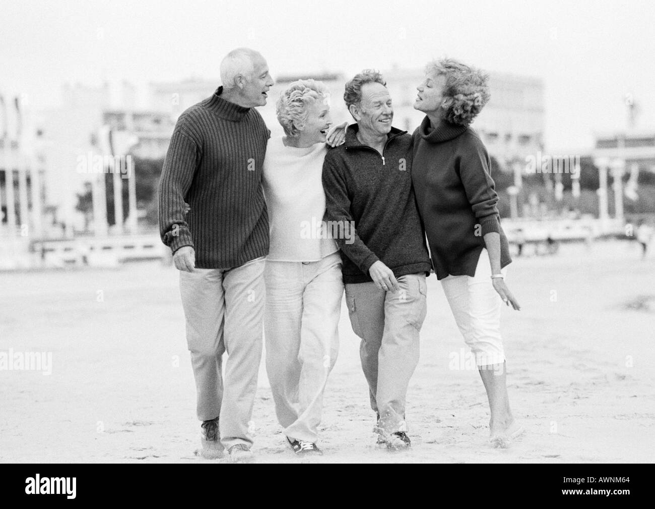 Les couples d'âge mûr walking on beach, B&W Banque D'Images