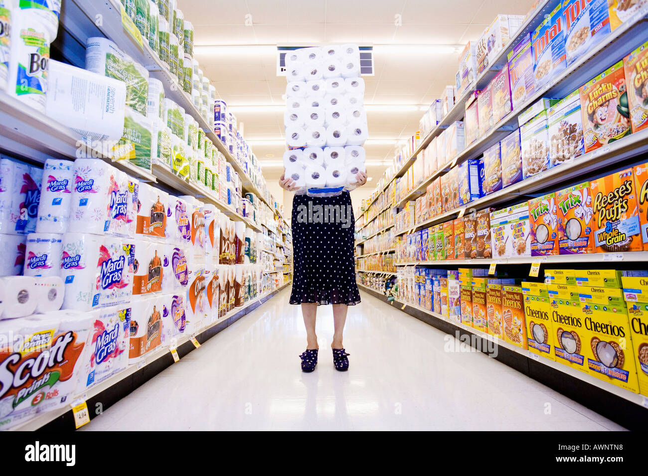 Woman carrying pile de papier toilette dans un supermarché Banque D'Images Woman carrying pile de papier toilette dans un supermarché Banque D'Images