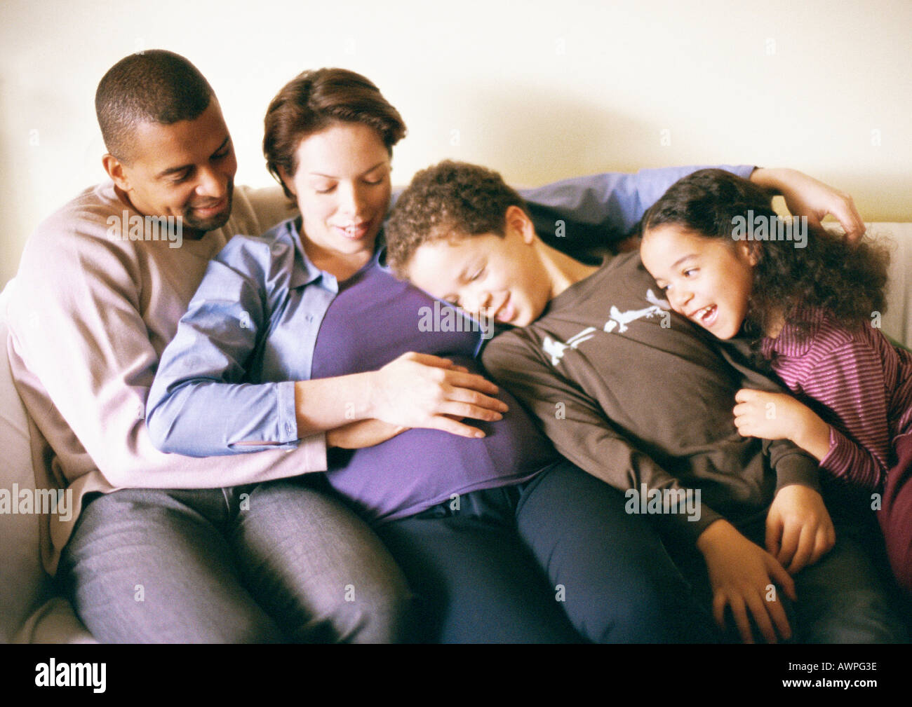 Couple et enfants sitting on sofa Banque D'Images