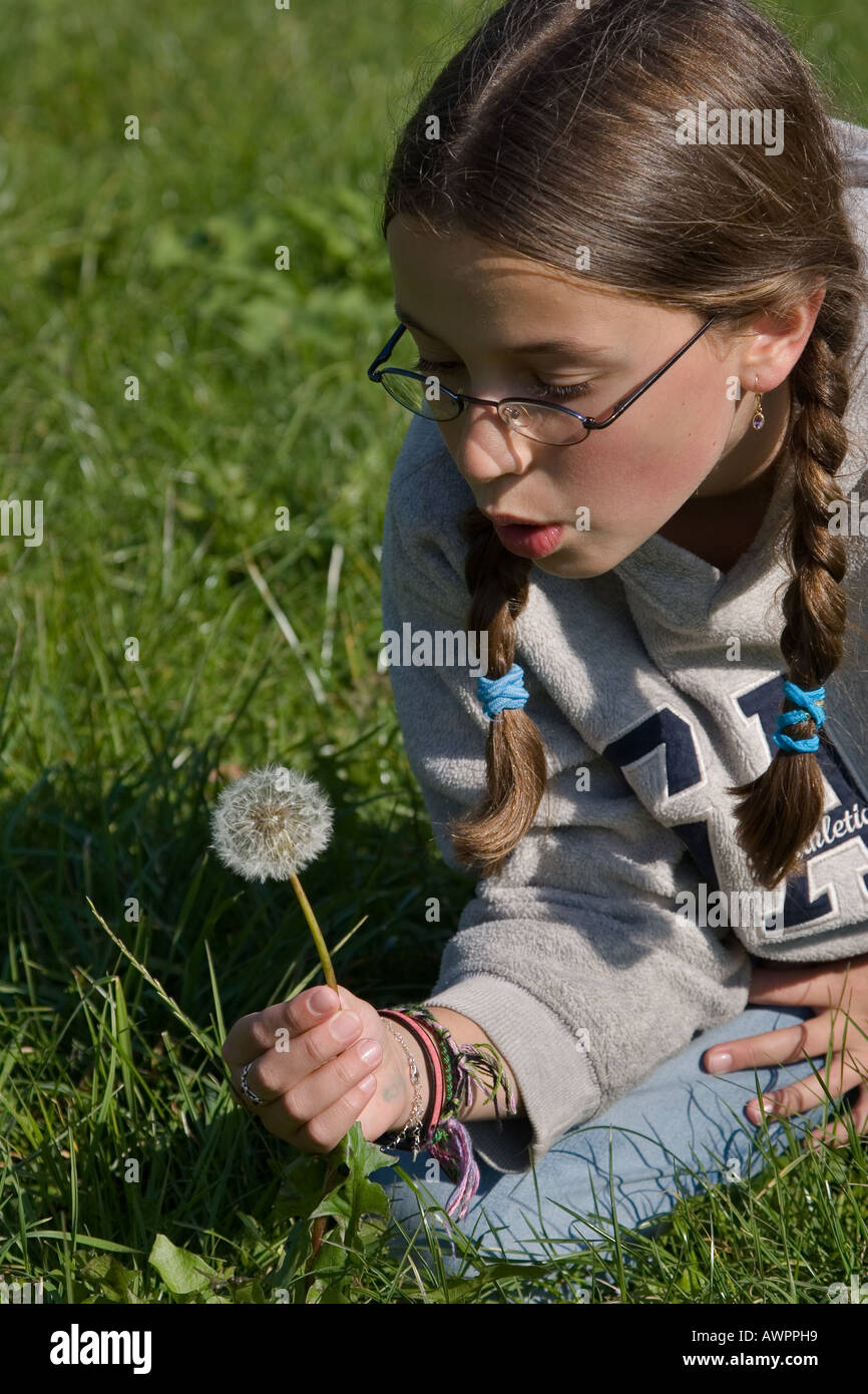 Stock Photo d'une jeune fille avec des verres en soufflant sur un Pissenlit Réveil Banque D'Images