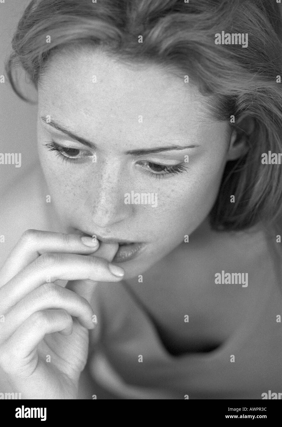 Woman biting nail, close-up, b&w Banque D'Images