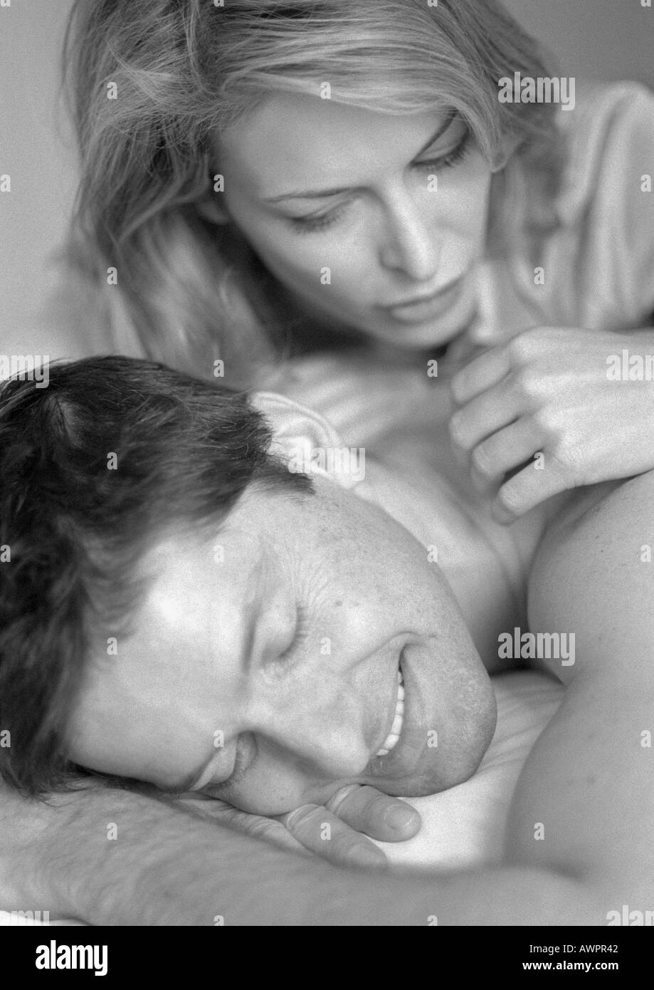 L'homme et la femme lying on bed, close-up, b&w Banque D'Images