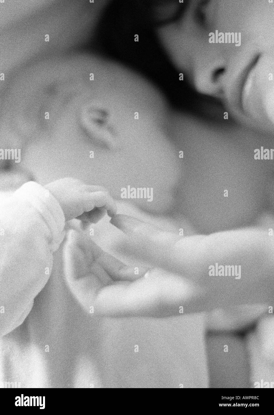 Mère avec enfant, jouant avec la main de bébé, close-up, b&w Banque D'Images