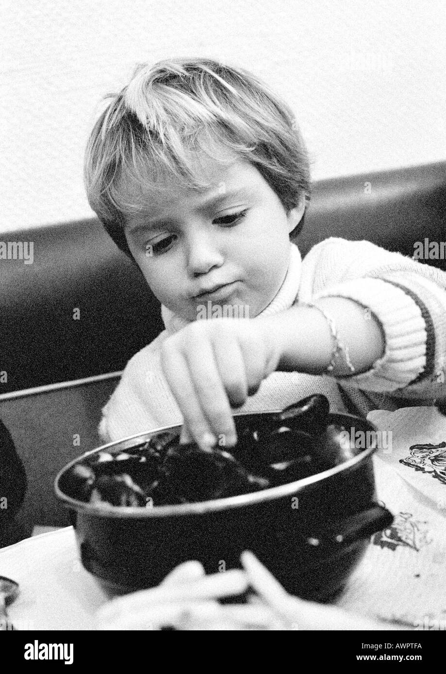 Enfant de manger des fruits de mer, portrait, b&w. Banque D'Images