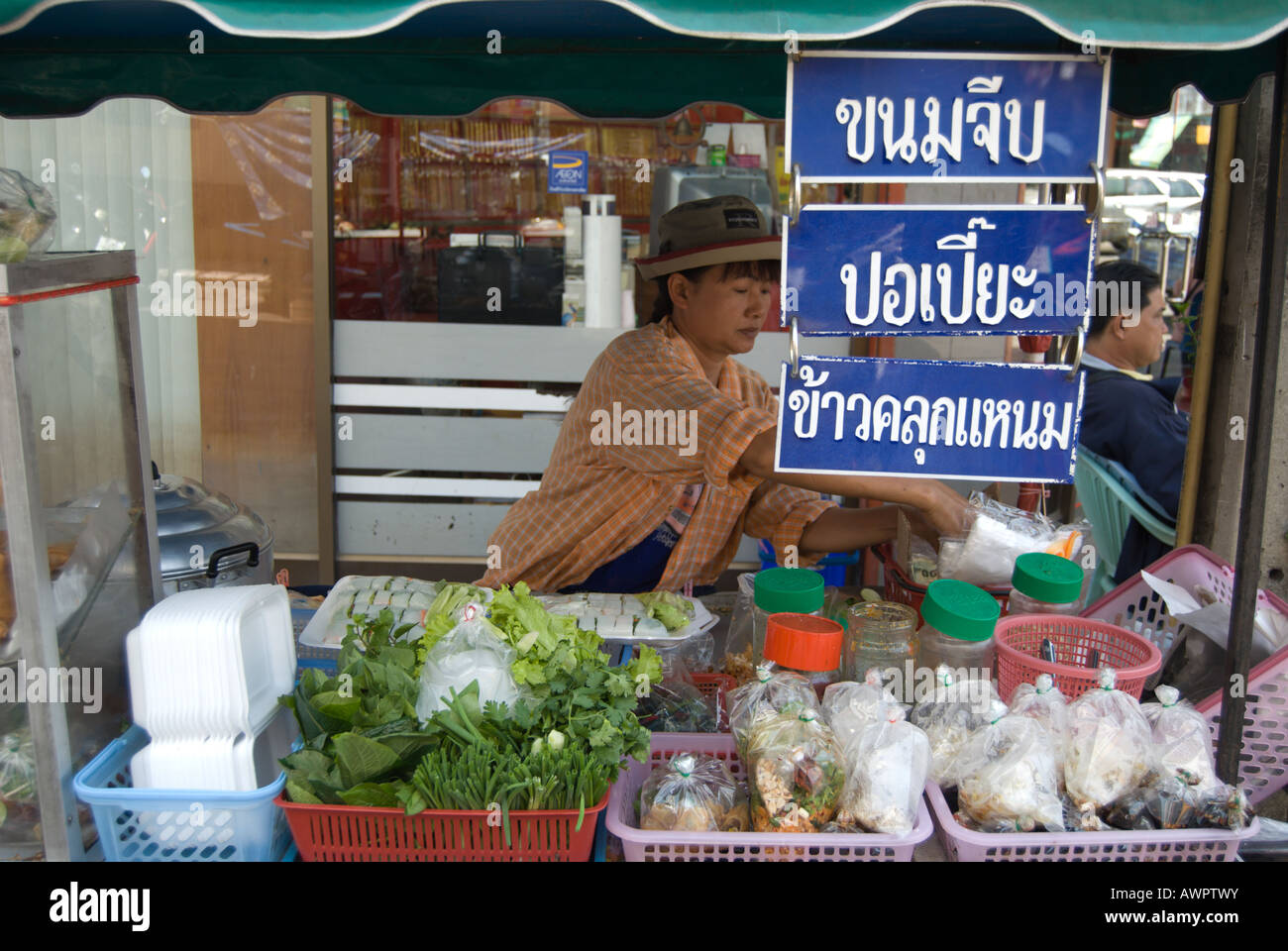 De son étal, cette femelle thai food fournisseur propose des rouleaux de printemps, des dim sum et autres plats Banque D'Images